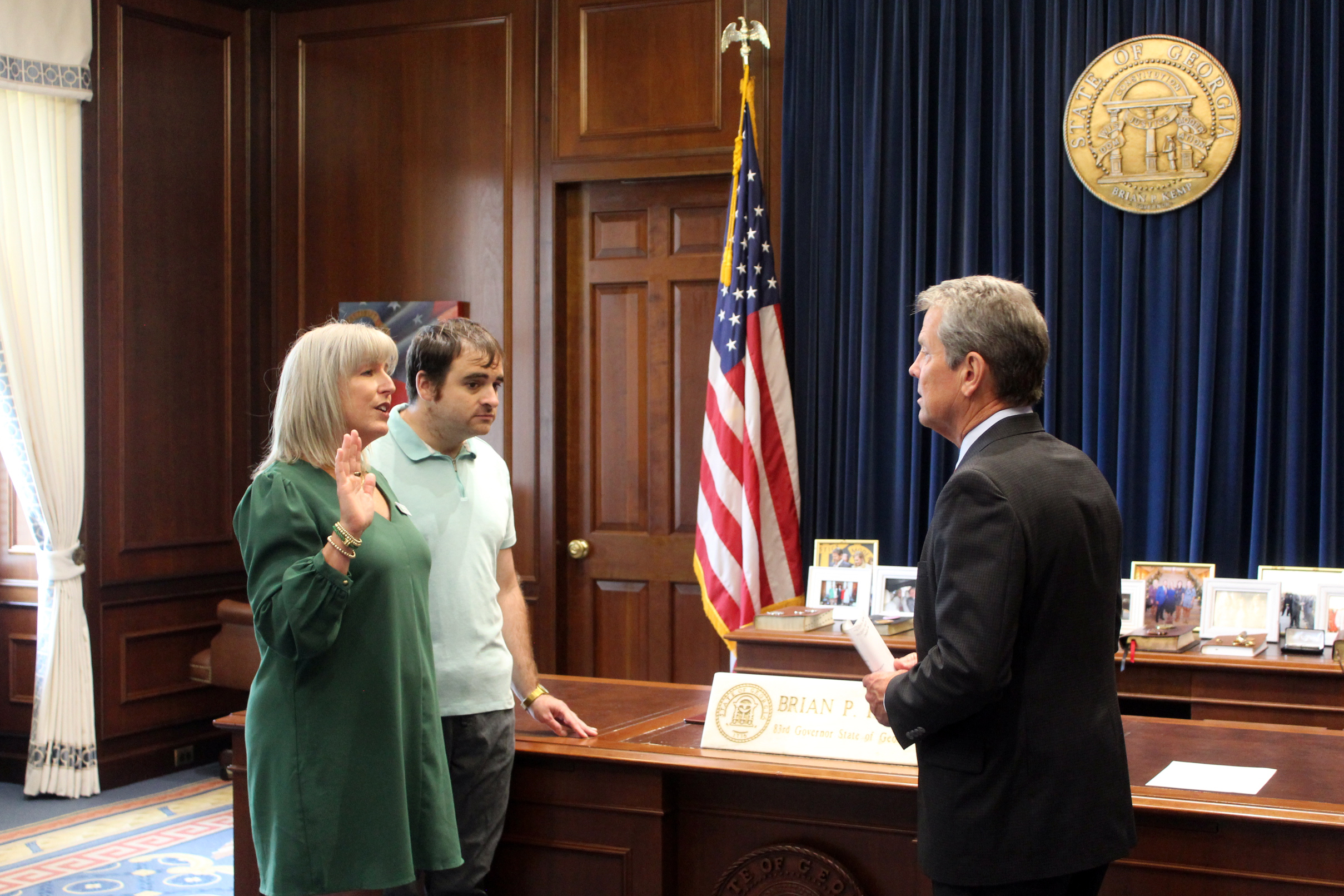 Frazer CEO DeAnna Julian, accompanied by extended family member Ryan Ramirez, is sworn in by Governor Kemp
