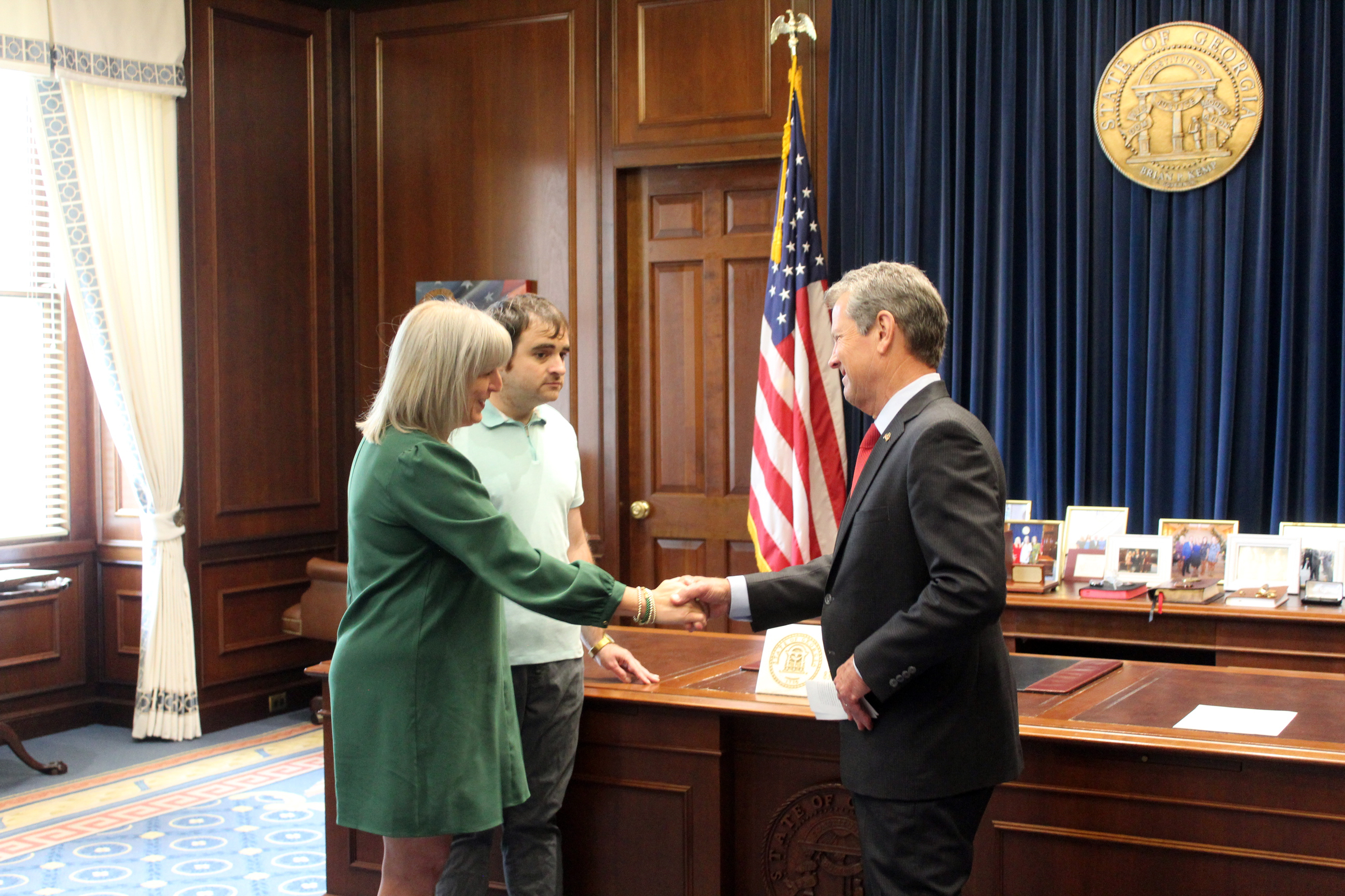 Frazer CEO DeAnna Julian, accompanied by extended family member Ryan Ramirez, is sworn in by Governor Kemp